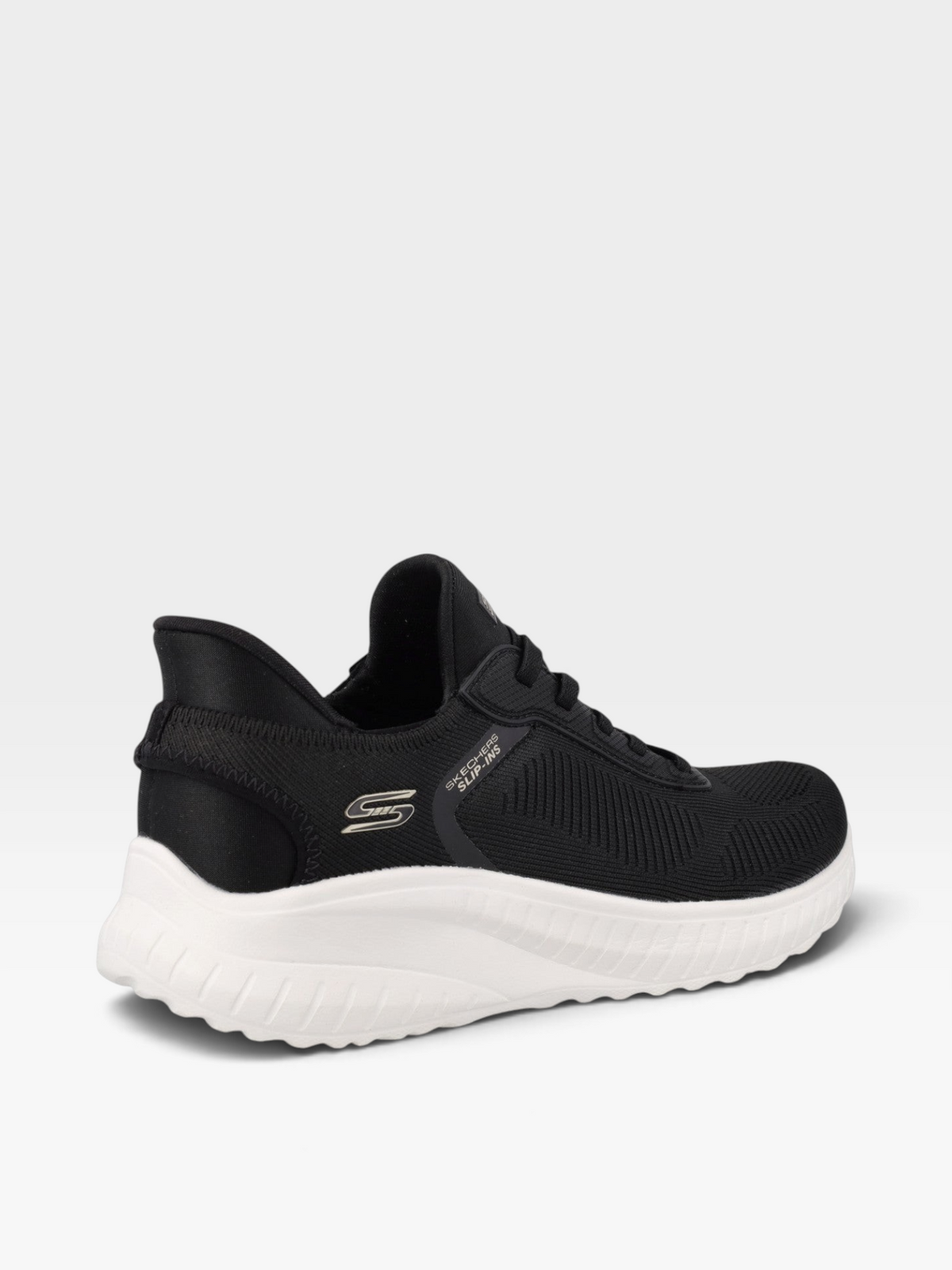 Tenis Skechers de mujer en color negro con tejido engineered knit y suela blanca, disponibles en oklahoma